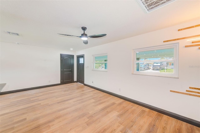 empty room with light wood-type flooring, visible vents, ceiling fan, and baseboards