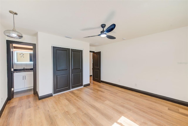 unfurnished bedroom featuring light wood finished floors, visible vents, a ceiling fan, connected bathroom, and baseboards