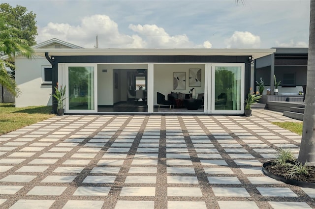 rear view of house with a patio and stucco siding