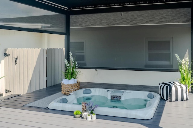 wooden terrace featuring fence and hot tub deck surround