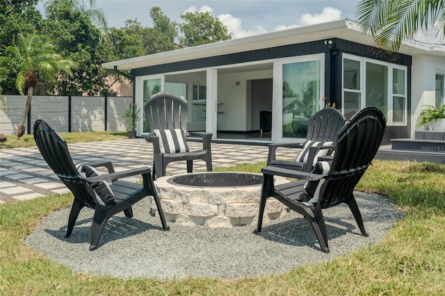 view of patio / terrace featuring an outdoor fire pit and fence