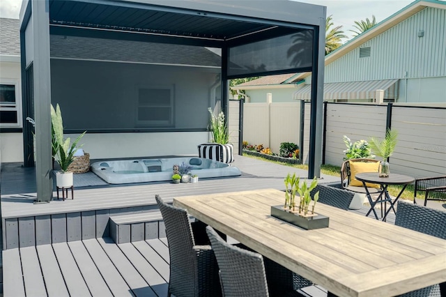 wooden terrace featuring outdoor dining space, hot tub deck surround, and fence