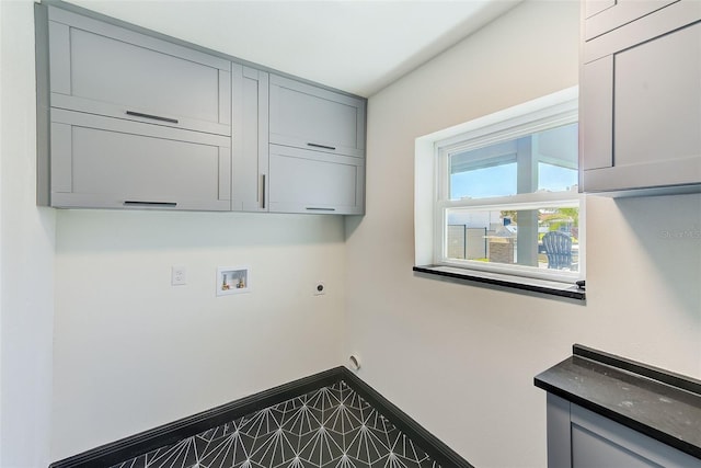 clothes washing area with baseboards, hookup for a washing machine, cabinet space, and hookup for an electric dryer