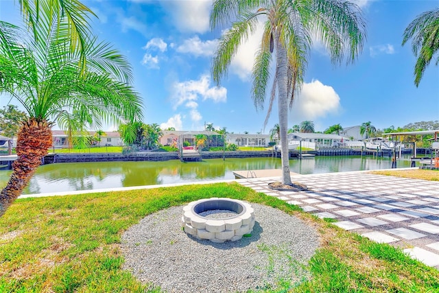 exterior space featuring a water view, a residential view, and a fire pit