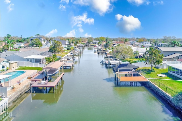 view of dock featuring a water view, boat lift, and a residential view