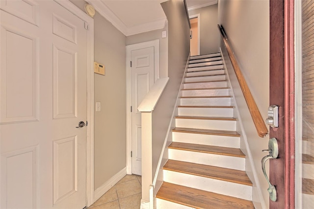 stairway with ornamental molding and tile patterned floors