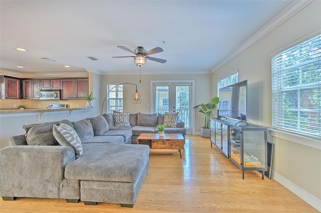 living room featuring crown molding, light hardwood / wood-style flooring, french doors, and ceiling fan