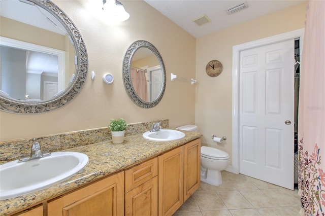 bathroom featuring tile patterned flooring, vanity, and toilet