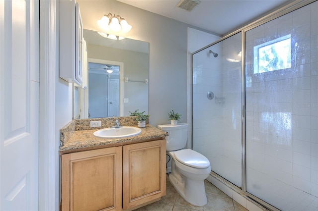 bathroom featuring vanity, toilet, a shower with shower door, and tile patterned flooring