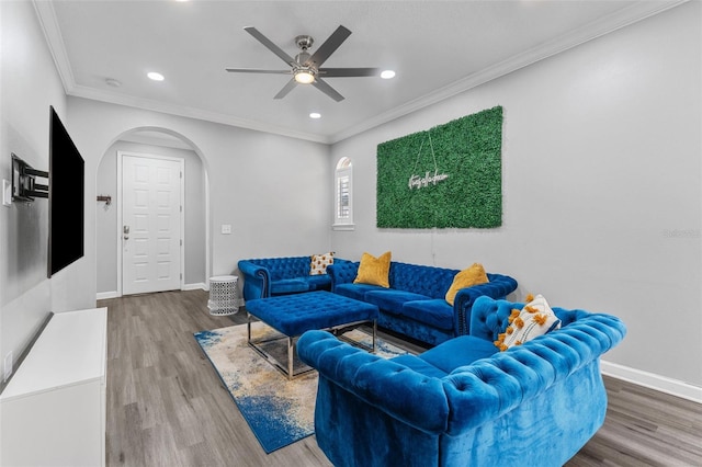 living room featuring hardwood / wood-style flooring, ornamental molding, and ceiling fan