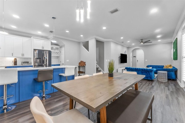 dining area featuring crown molding, ceiling fan, sink, and light wood-type flooring