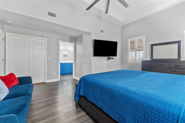 bedroom with ensuite bathroom, dark wood-type flooring, and ceiling fan