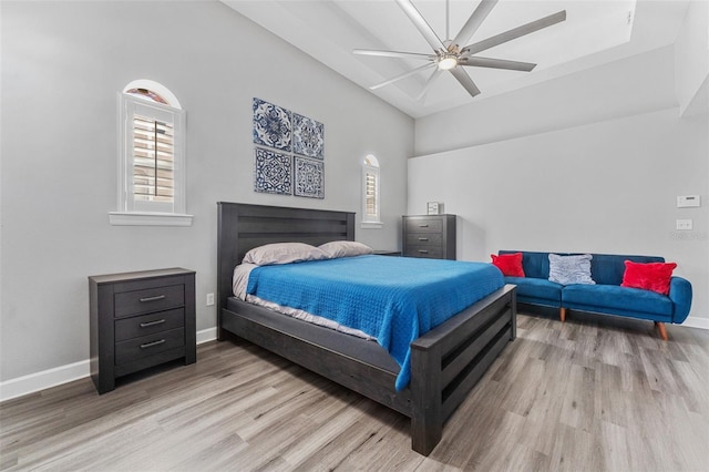 bedroom with ceiling fan, light hardwood / wood-style floors, and multiple windows