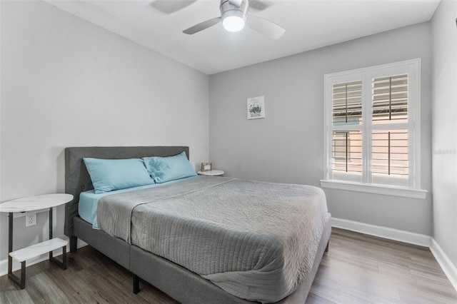 bedroom with dark hardwood / wood-style flooring and ceiling fan