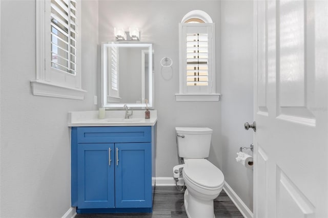 bathroom featuring vanity, toilet, and hardwood / wood-style floors