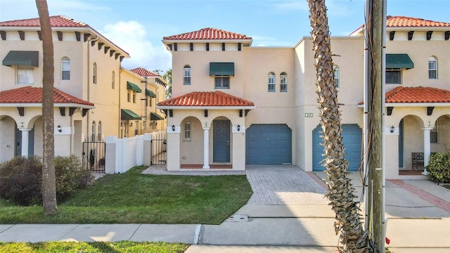 mediterranean / spanish-style house featuring a garage and a front yard