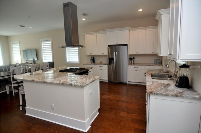 kitchen featuring stainless steel fridge, island exhaust hood, light stone countertops, white cabinets, and a kitchen island