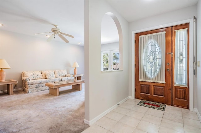 foyer with ceiling fan and light carpet