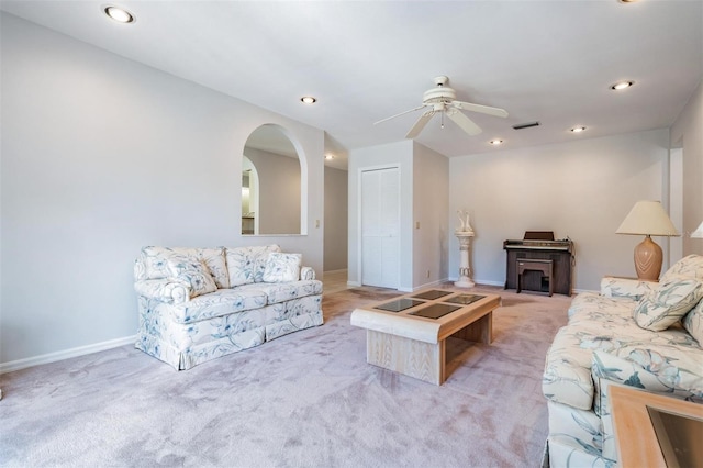 carpeted living room with ceiling fan