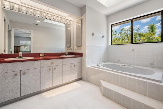 bathroom featuring vanity and tiled bath