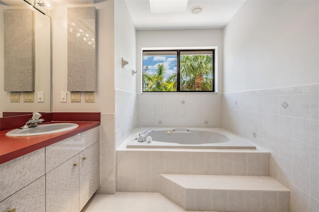 bathroom featuring vanity and a relaxing tiled tub