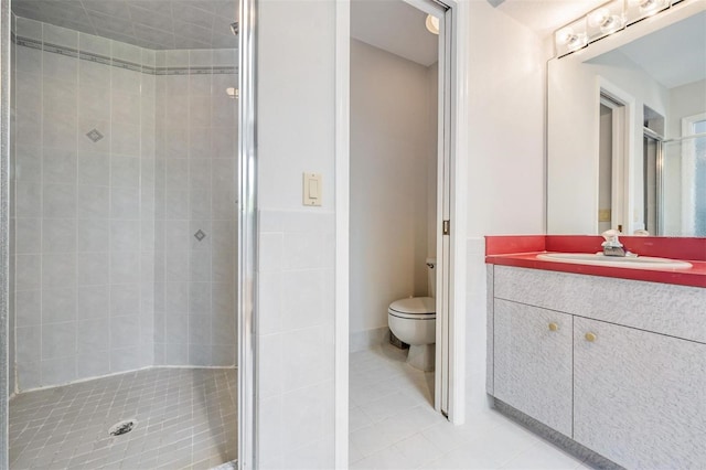 bathroom featuring tile patterned flooring, vanity, toilet, and an enclosed shower