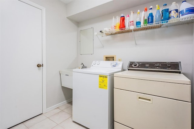 washroom with light tile patterned flooring, separate washer and dryer, and sink