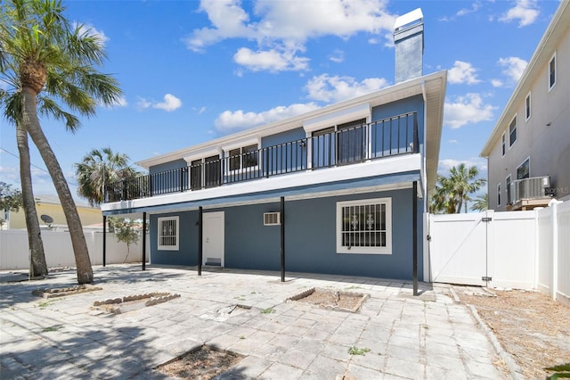 back of house featuring cooling unit, a patio, and a balcony