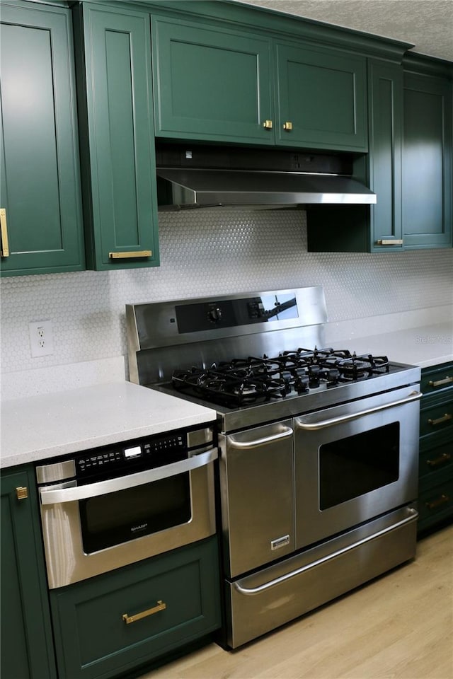 kitchen with green cabinetry and appliances with stainless steel finishes