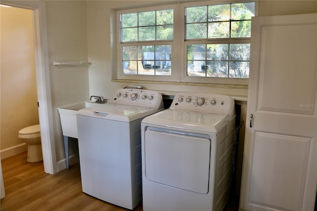 laundry room with light hardwood / wood-style floors and washing machine and dryer