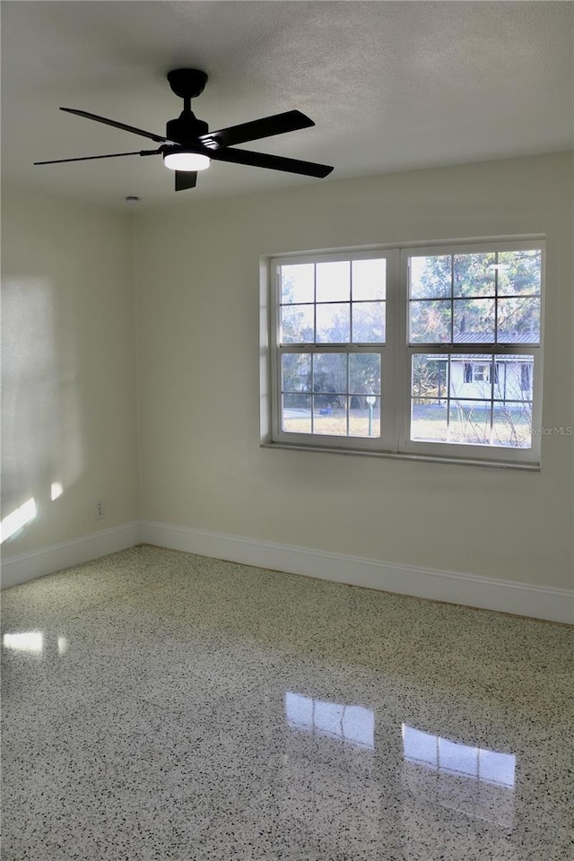 unfurnished room featuring plenty of natural light, a textured ceiling, and ceiling fan