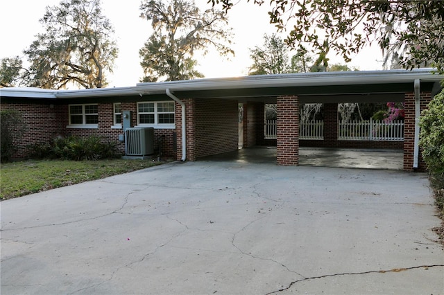 view of front of house with central AC unit and a carport