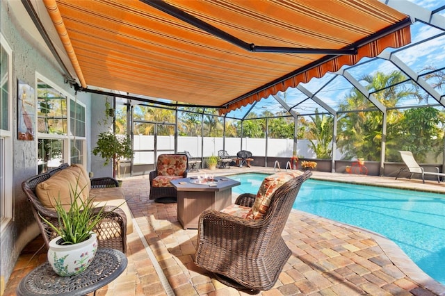 view of swimming pool with glass enclosure, a patio area, and a fire pit