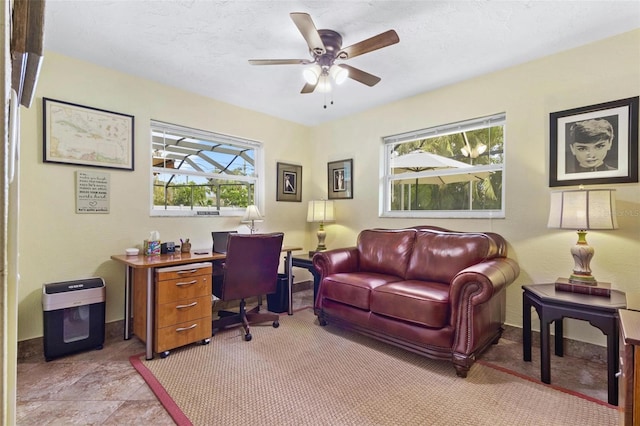 office featuring ceiling fan, a textured ceiling, and a healthy amount of sunlight