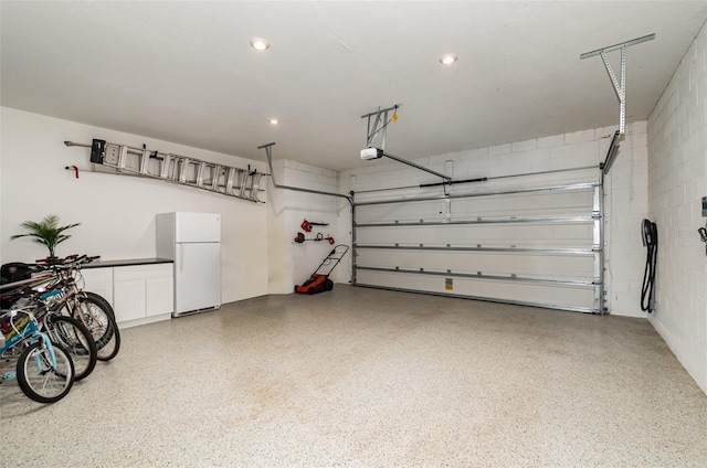 garage featuring a garage door opener and white refrigerator