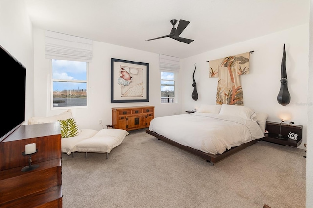 carpeted bedroom featuring multiple windows and ceiling fan