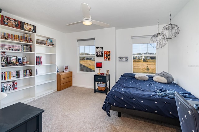 bedroom featuring multiple windows, light colored carpet, and ceiling fan