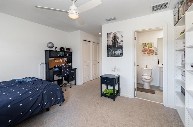 bedroom with ceiling fan, a closet, ensuite bathroom, and light carpet