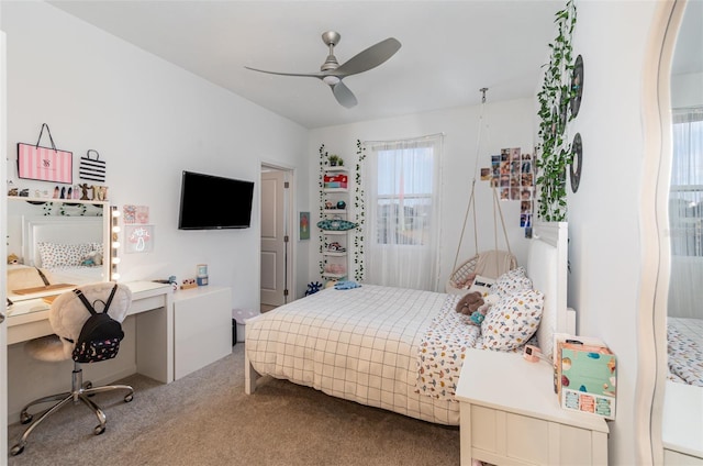 carpeted bedroom featuring built in desk and ceiling fan