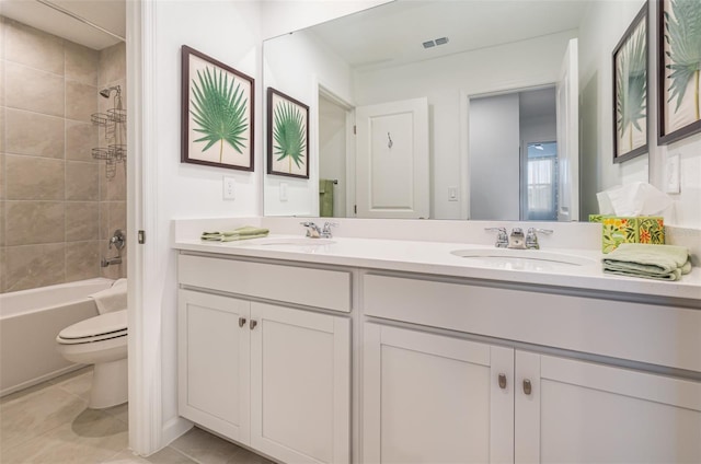 full bathroom featuring tiled shower / bath, vanity, tile patterned floors, and toilet