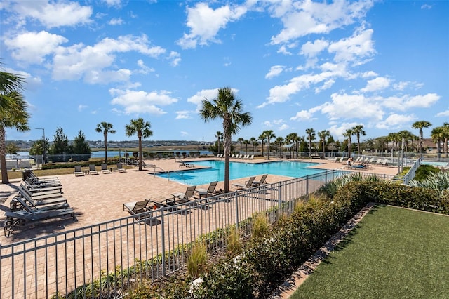 view of swimming pool with a water view and a patio area