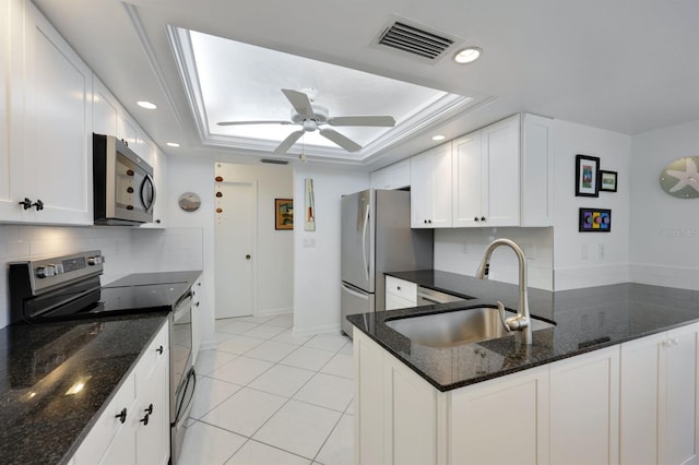 kitchen featuring sink, a raised ceiling, white cabinets, and appliances with stainless steel finishes