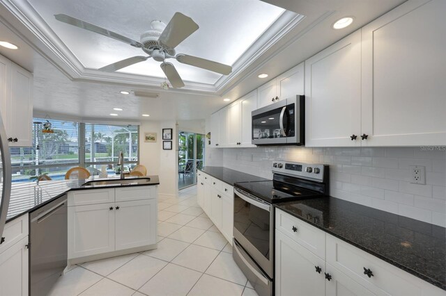 kitchen featuring a raised ceiling, white cabinetry, and appliances with stainless steel finishes