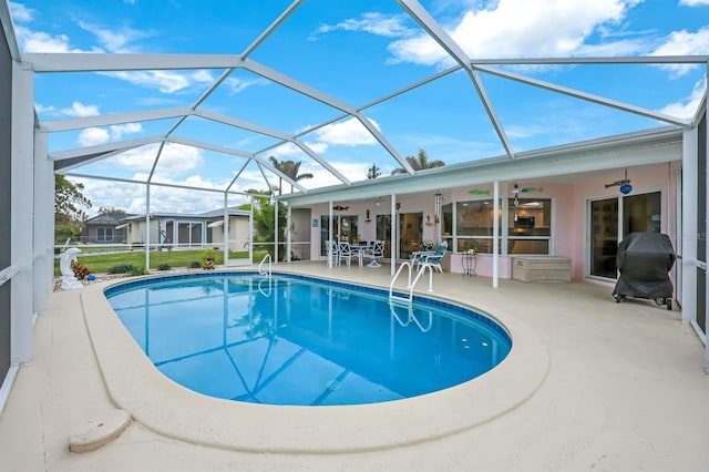 view of pool featuring ceiling fan, a patio, grilling area, and glass enclosure