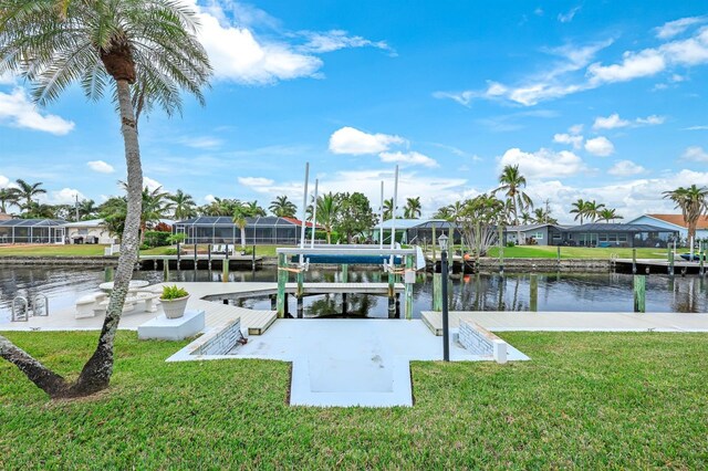 dock area with a lawn and a water view