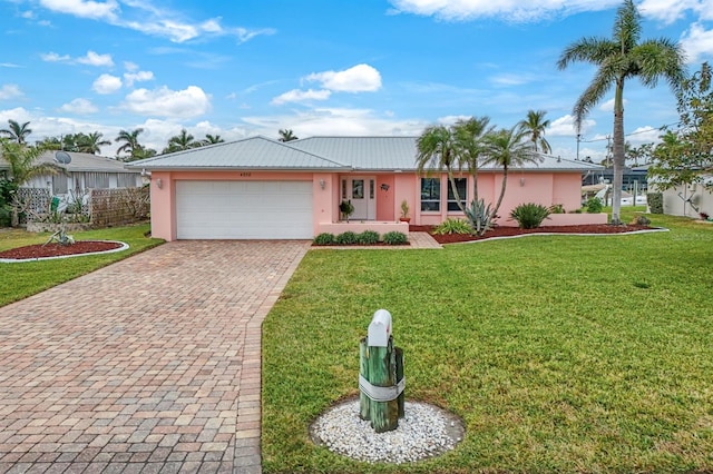 ranch-style home featuring a garage and a front lawn