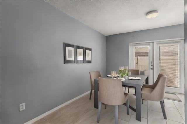 dining space featuring french doors and light tile patterned flooring