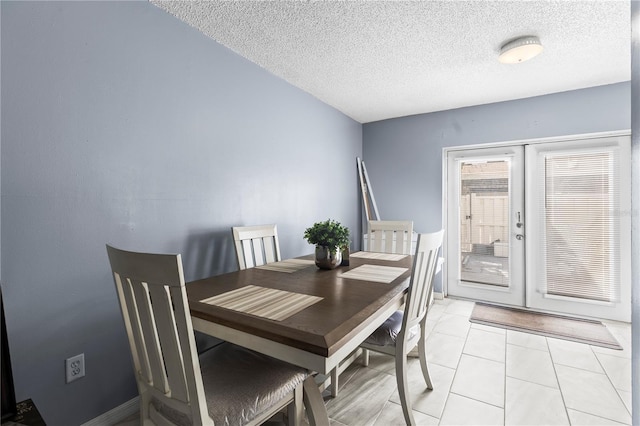 tiled dining area with a textured ceiling and french doors