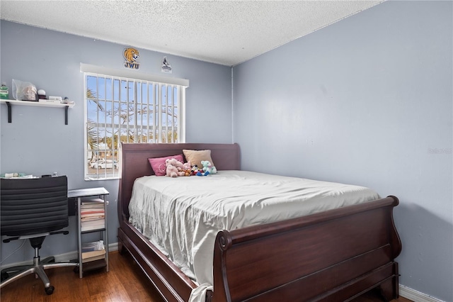 bedroom featuring a textured ceiling and dark hardwood / wood-style flooring