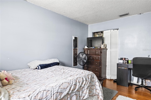 bedroom with dark hardwood / wood-style flooring, a closet, and a textured ceiling